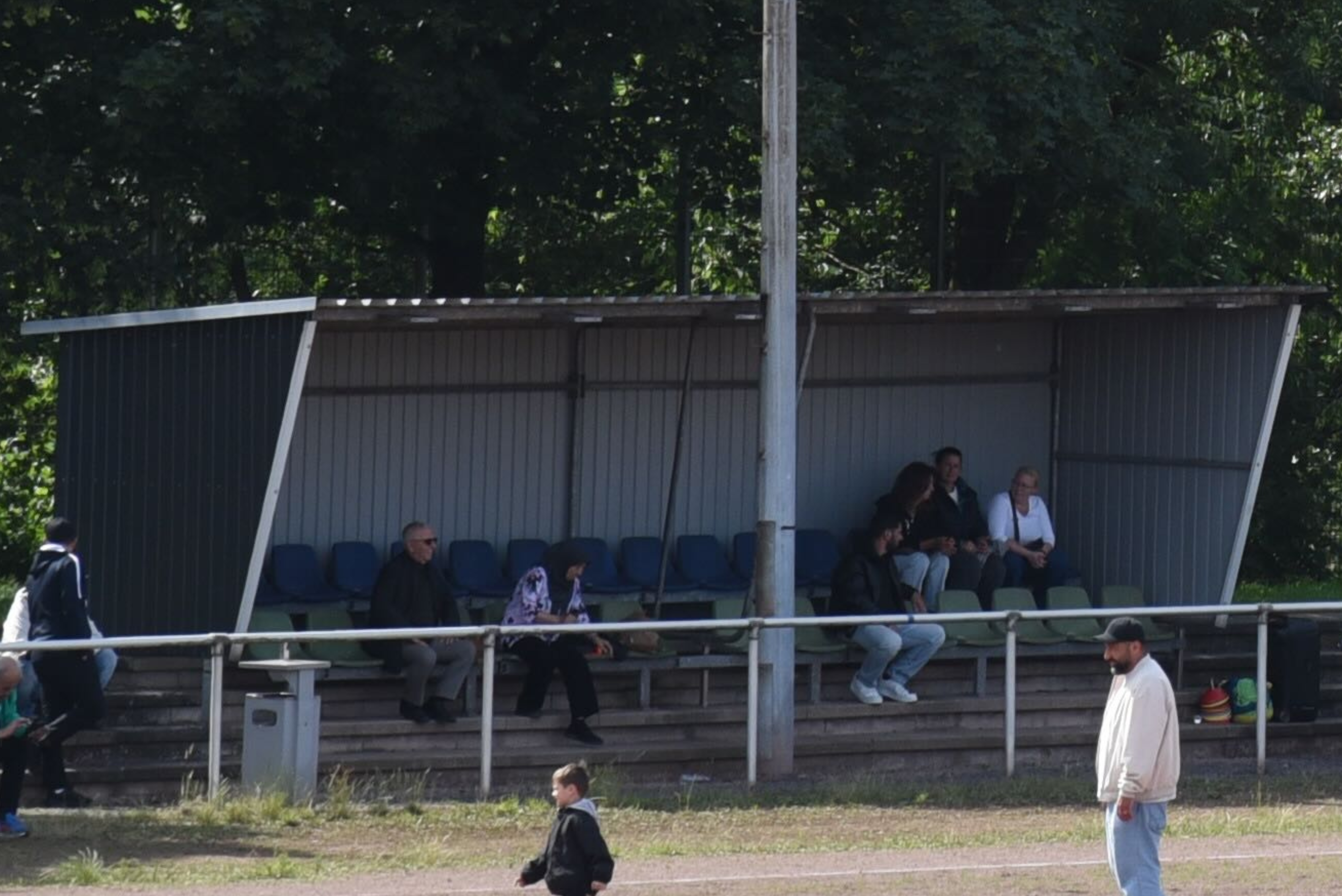 Überdachte Gästetribüne mit Sitzschalen am Rand des Spielfeldes