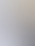 Eine lächelnde Frau mit Brille sitzt an einem Bürotisch mit Computer und Rechner.
