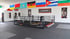 Boxring in einem Fitnessstudio mit Sandsäcken und internationalen Flaggen an der Wand.