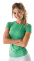 Lächelnde junge Frau mit blondem Haar und grüner Sportkleidung, die mit verschränkten Armen dasteht.