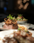 Rinderfilet mit Röstzwiebeln und frischen Kräutern, dazu Beilagensalat und Soße.
