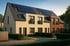 Reihenhäuser mit Solarmodulen auf den Dächern und einer Frau, die auf dem Bürgersteig geht.