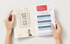 Hands holding an open brochure showing a floor plan and "HVS Market Research" with projected room rates.