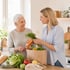 Haushaltshilfe bringt frische Einkäufe für eine Seniorin