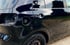 Nahaufnahme eines Geländewagens mit freiliegender Aufhängung und Offroad-Bereifung, geparkt auf einem unebenen Gelände.