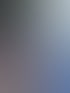 Eine Frau mit Mikrofon wird von einem Kameramann interviewt, im Hintergrund eine Rennstrecke.