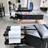 Row of black padded chiropractic adjustment tables with wooden legs and white headrest paper in a clinical office setting.