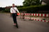 Christian Roßmann fährt lächelnd auf einem E-Roller über eine Baustelle.