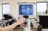 Hand hält RFID-Armband an ein EGYM Fitnessgerät-Display mit der Übungsanleitung Butterfly Reverse.