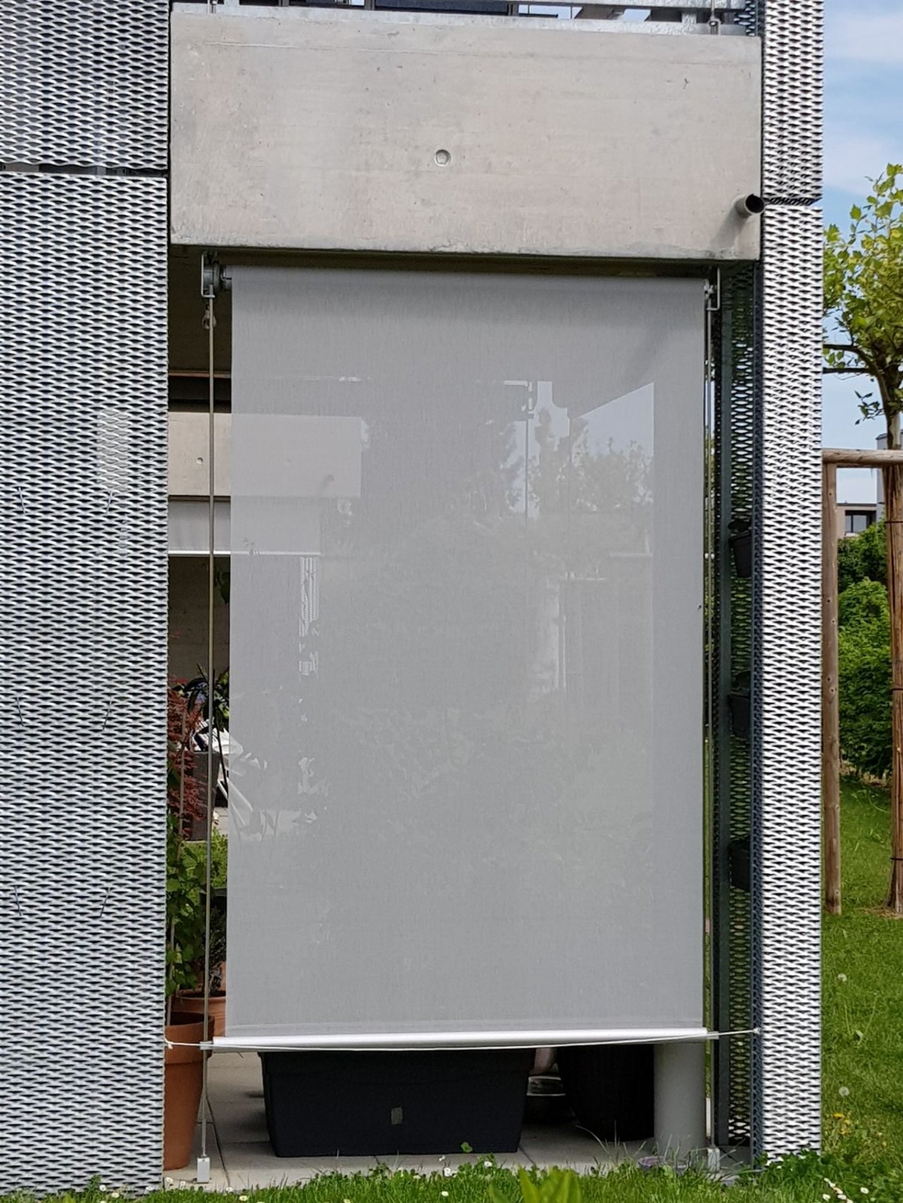 Seilgeführter Sonnenschutz an moderner Fassade