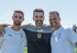 Drei Fußballtrainer in Trikots, darunter Gianluigi Buffon in der Mitte, lächeln in die Kamera.