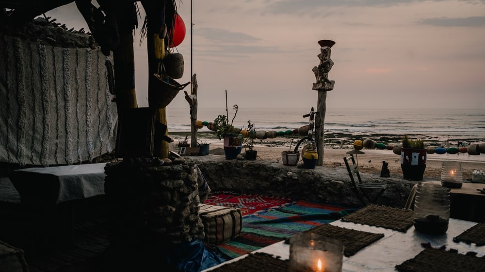 Gedeckter Platz mit Kerzen und Teppichen am Atlantik
