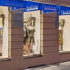 Schaufenster mit Dirndl-Trachten und blauen Markisen mit der Aufschrift „Dirndl-Truhe München“.