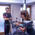 Eine Frau stellt den Lenker eines Triathlon-Zeitfahrrads ein, während ein Sportler im Hintergrund zuschaut.