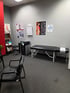 Chiropractic examination room with a black treatment table, and office chairs.
