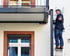 Handwerker montiert Balkon an der Fassade