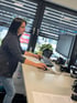 Eine Frau arbeitet an einem Stehpult mit Tastatur, Maus und zwei Monitoren.
