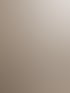 Eine Frau in einem trägerlosen, weißen Brautkleid mit Meerjungfrauen-Schnitt steht lächelnd vor einem Fenster.