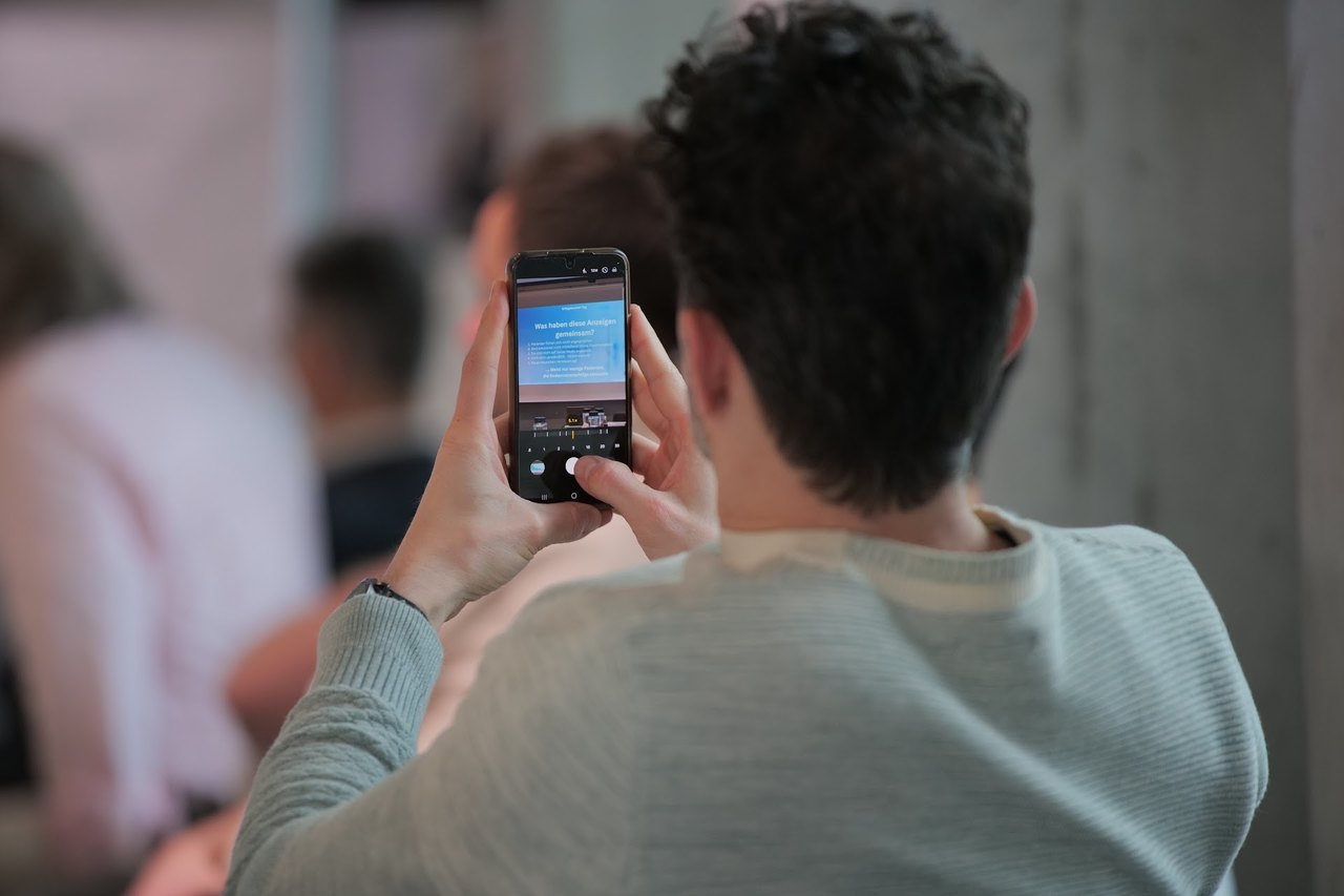 Teilnehmer fotografieren die Folien mit