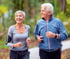 Active senior couple enjoying a revitalizing jog outdoors among trees