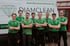 Eight men in green shirts with folded arms stand in front of a white "DIAMCLEAN" van.