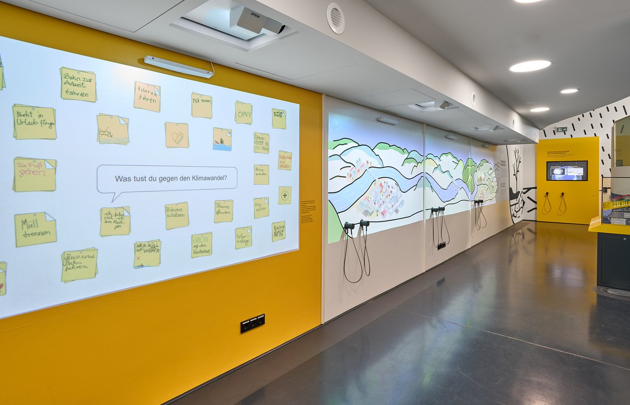 Die Interaktivwand im Mosellum Koblenz – digitale Klebezettel zur Frage ‚Was tust du gegen den Klimawandel?’ neben einer interaktiven Landschaftsprojektion