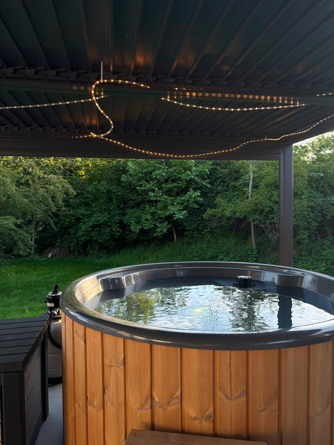 Outdoor-Whirlpool unter Pergola am Abend