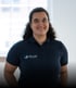 Porträt von Sophia Müller mit dunklen Locken im dunkelblauen Poloshirt mit dem Logo Faller Sicherheitstechnik GmbH.
