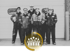 Team von Elektrikern in Schutzkleidung und Helmen vor einem Industriegebäude – Gruppenfoto von Fachkräften auf einer Baustelle