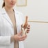 Ärztin im weißen Kittel hält ein anatomisches Modell eines menschlichen Kniegelenks in den Händen.