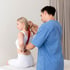 Physiotherapist assists woman with back stretch for herniated disc