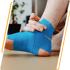 Person touches a blue-taped ankle during sports injury treatment.