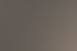 Ein Mann mit verschränkten Armen lächelt vor einer Gruppe von Kollegen in einer Fabrikhalle.