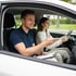 Fahrlehrer im Fahrschulauto im Gespräch mit einer Fahrschülerin