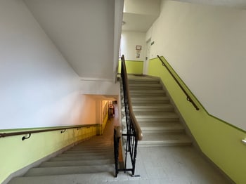 Treppenhaus mit grün gestrichener Wand und Handlauf