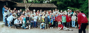 Familien beim Grillen und Kicken auf einer Wiese