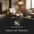 Wohnzimmer mit beigem Sessel, Holzwänden, Stehlampe und Couch; Logo "TK RAUMGESTALTUNG", Text "Räume mit Charakter".