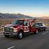 Towing Sandy long-distance towing service transporting a classic sedan along an open highway for safe vehicle relocation.