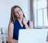 Woman at laptop rubbing shoulder in pain