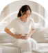 A woman holding her bloated stomach.