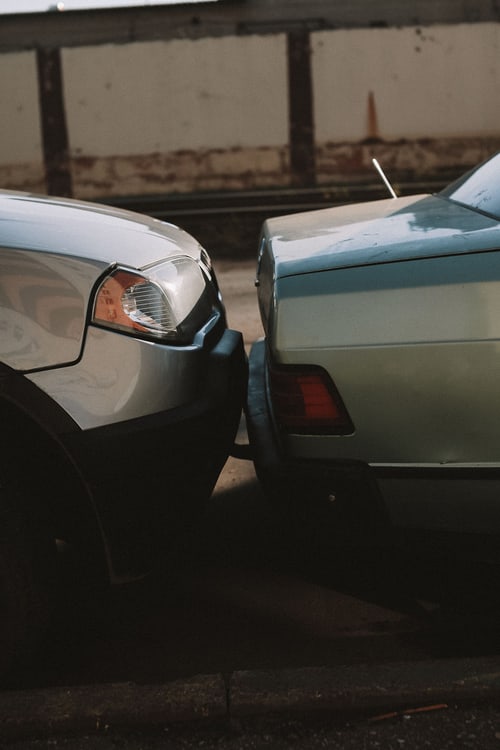 Minor car accident with rear bumper damage on a road in Cranston, Rhode Island