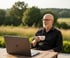Christoph Scheel genießt entspannt seinen Feierabend in der Natur, während sein KI-Chatbot von SCHEELMEDIA im Hintergrund Kundenanfragen automatisiert.