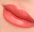 Nahaufnahme von Lippen mit permanentem Make-up in Pfirsichfarbe.