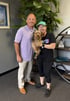 Family wellness setting with couple holding a dog in a clinic room