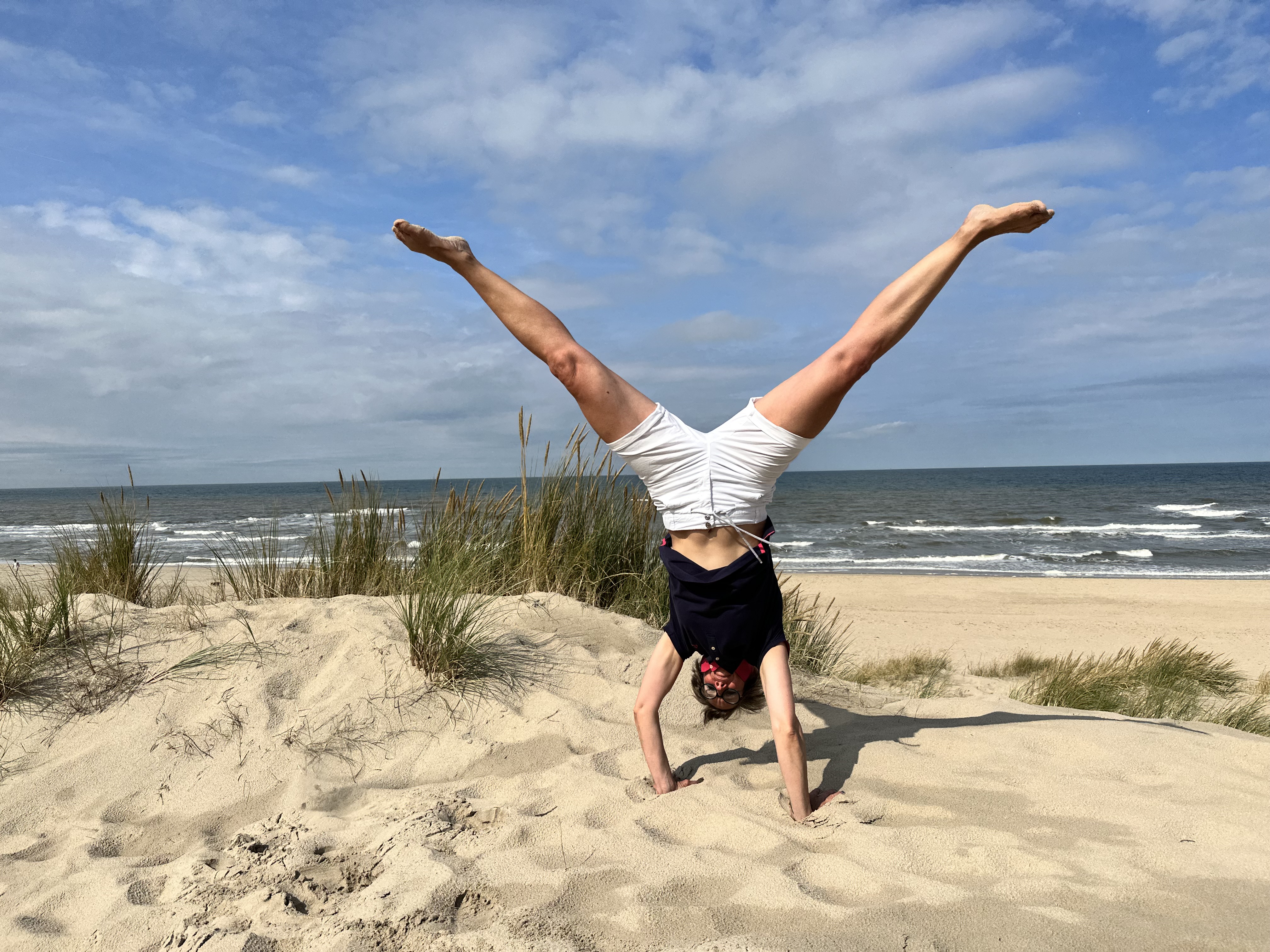 Nicole Matthiessen schlägt ein Rad am Strand der Nordsee, Bewegung und Freiheit