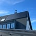 Dunkle Solarmodule auf einem Satteldach mit Dachfenster