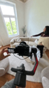 Eine Kamera auf einem Gimbal filmt eine Frau, die ein Kissen auf ein helles, geschwungenes Sofa in einem Wohnzimmer legt.