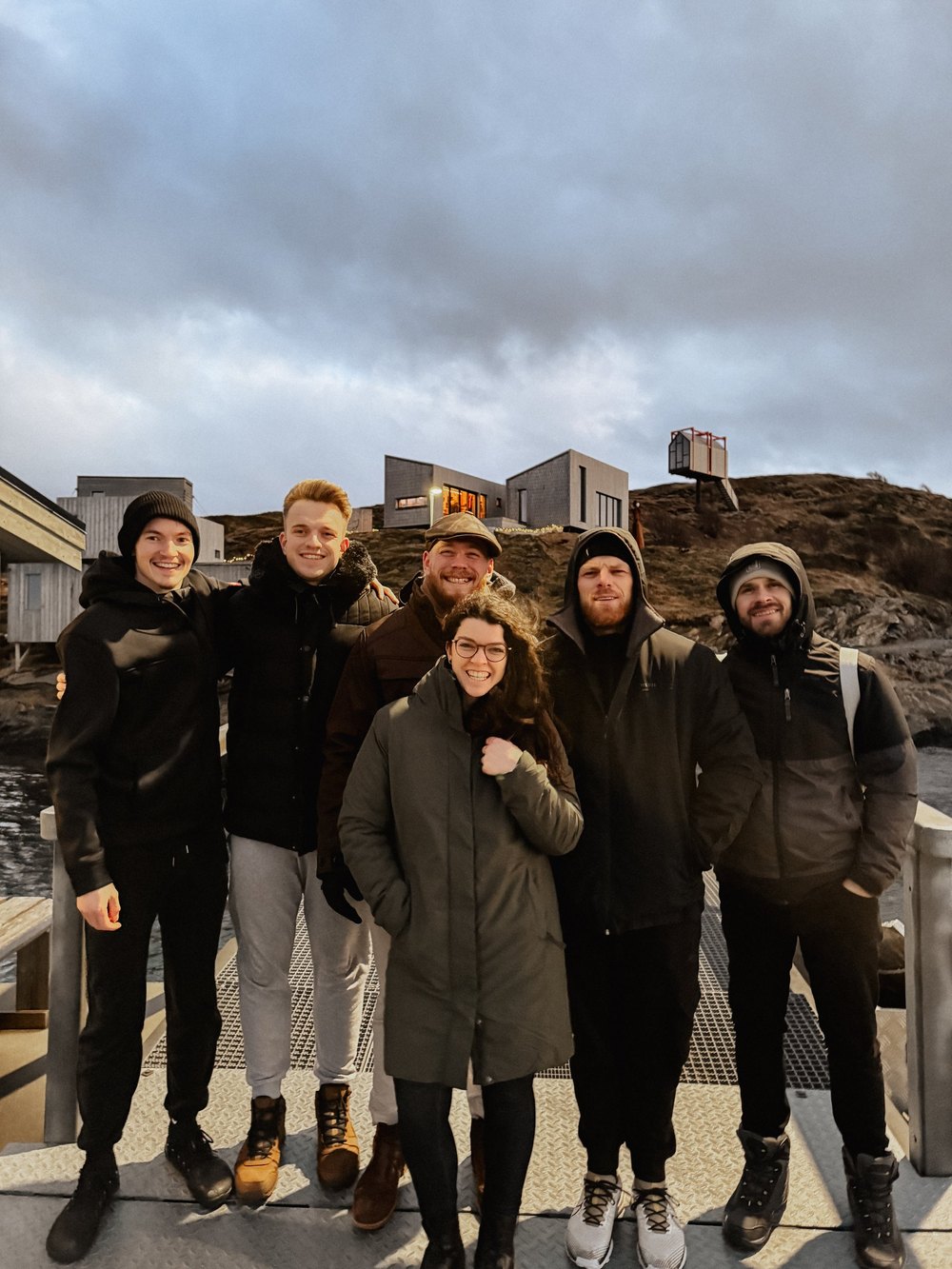 Gruppe in Winterjacken lächelt auf der Terrasse