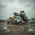 Radlader verlädt Schotter auf die Ladefläche eines Lkw – illustratives Motiv