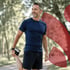 Fit man in navy and black stretches in the park, aiding cellular repair.